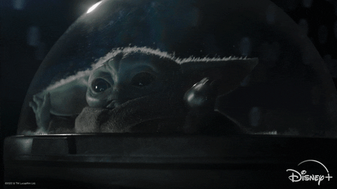 Baby Yoda flung back in their seat with their arms raised as they fly through space